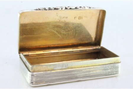 Caixa de rapé em prata guilhochada envolvendo cartela para monograma, interior dourado e relevos na tampa para abertura.
